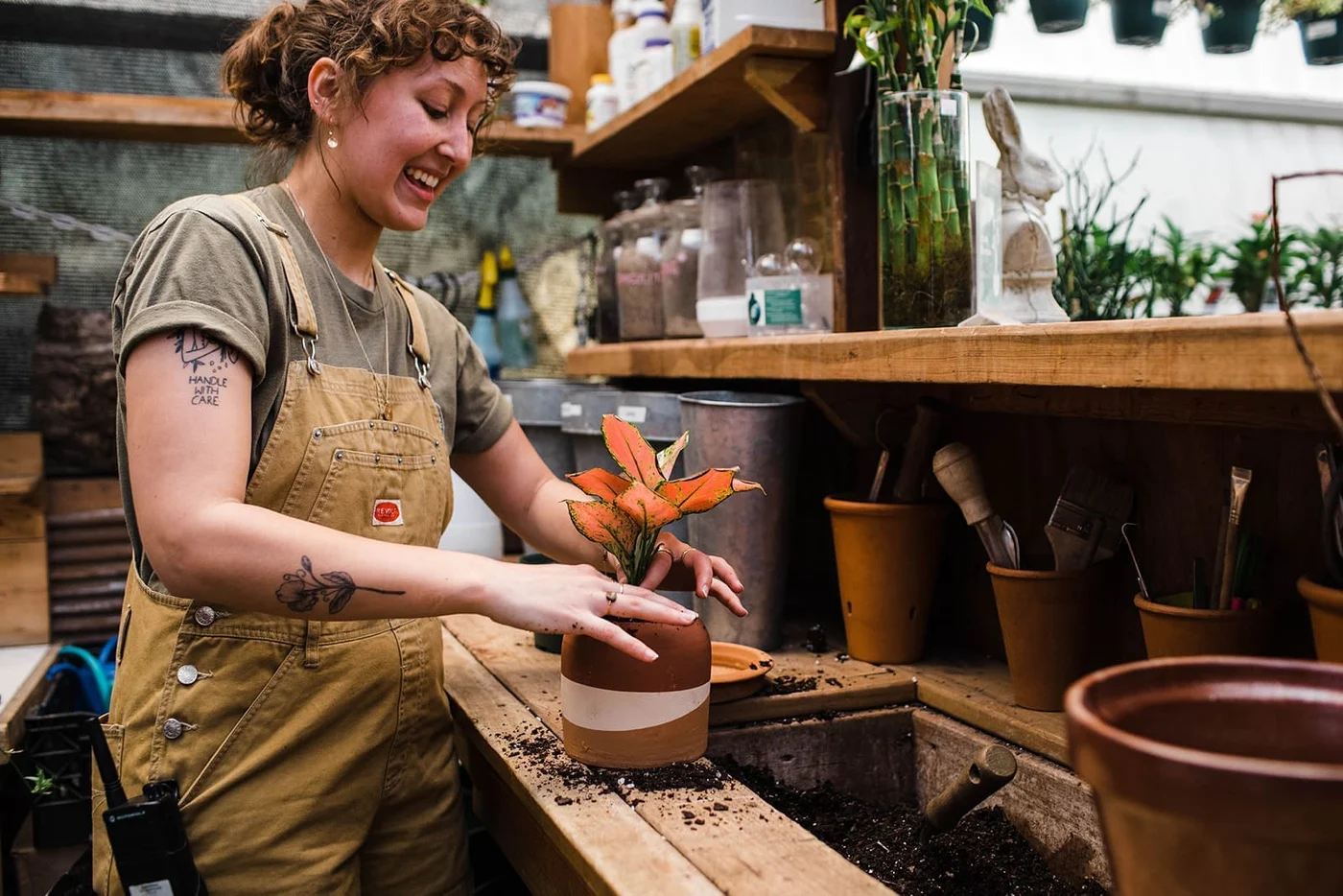 A Gardens of Babylon team member working with plants in the garden center
