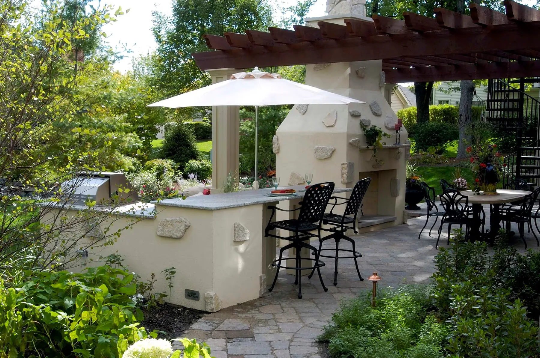 Outdoor kitchen and bar on one side of the fireplace.