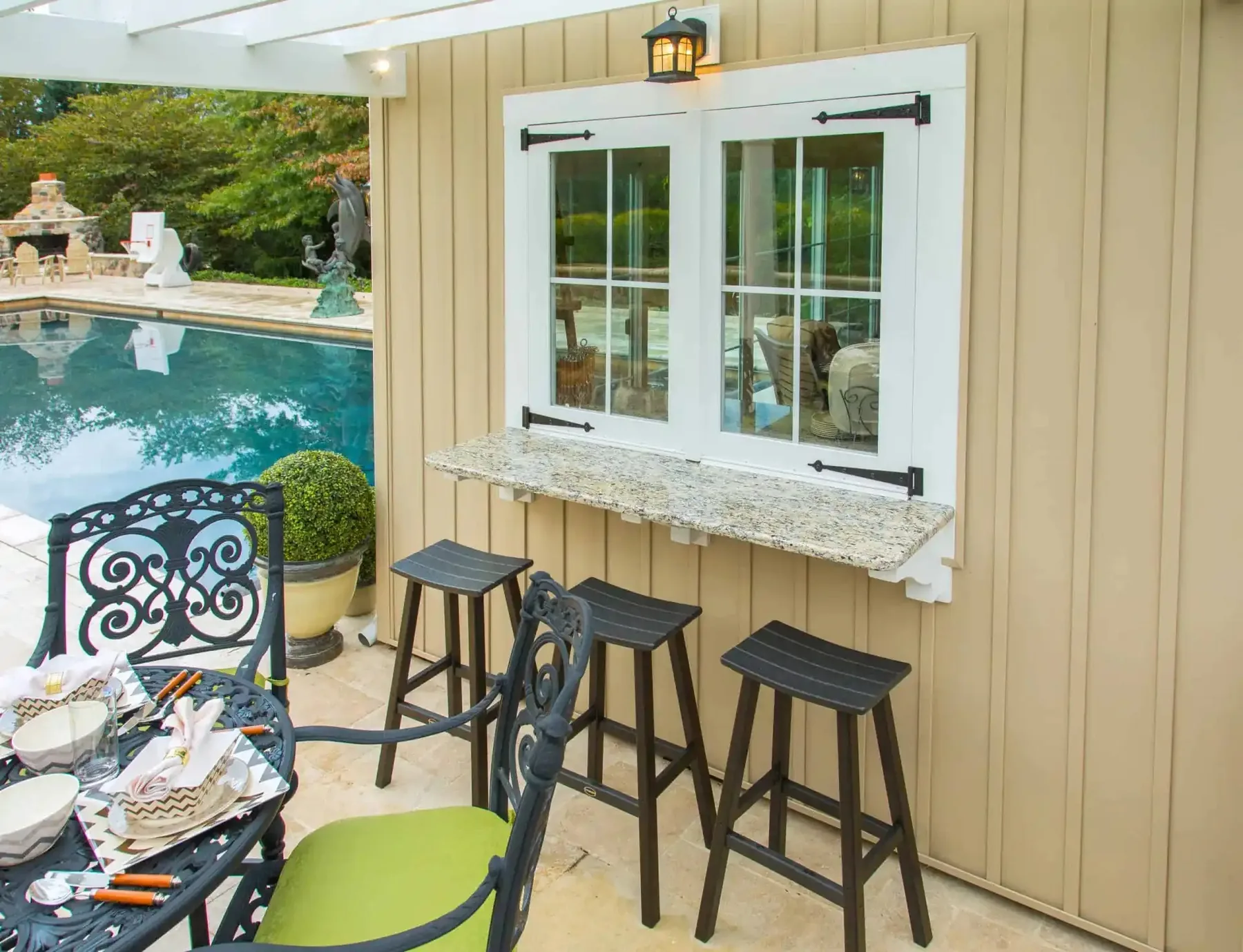 Open serving window with stools outside the pool house.
