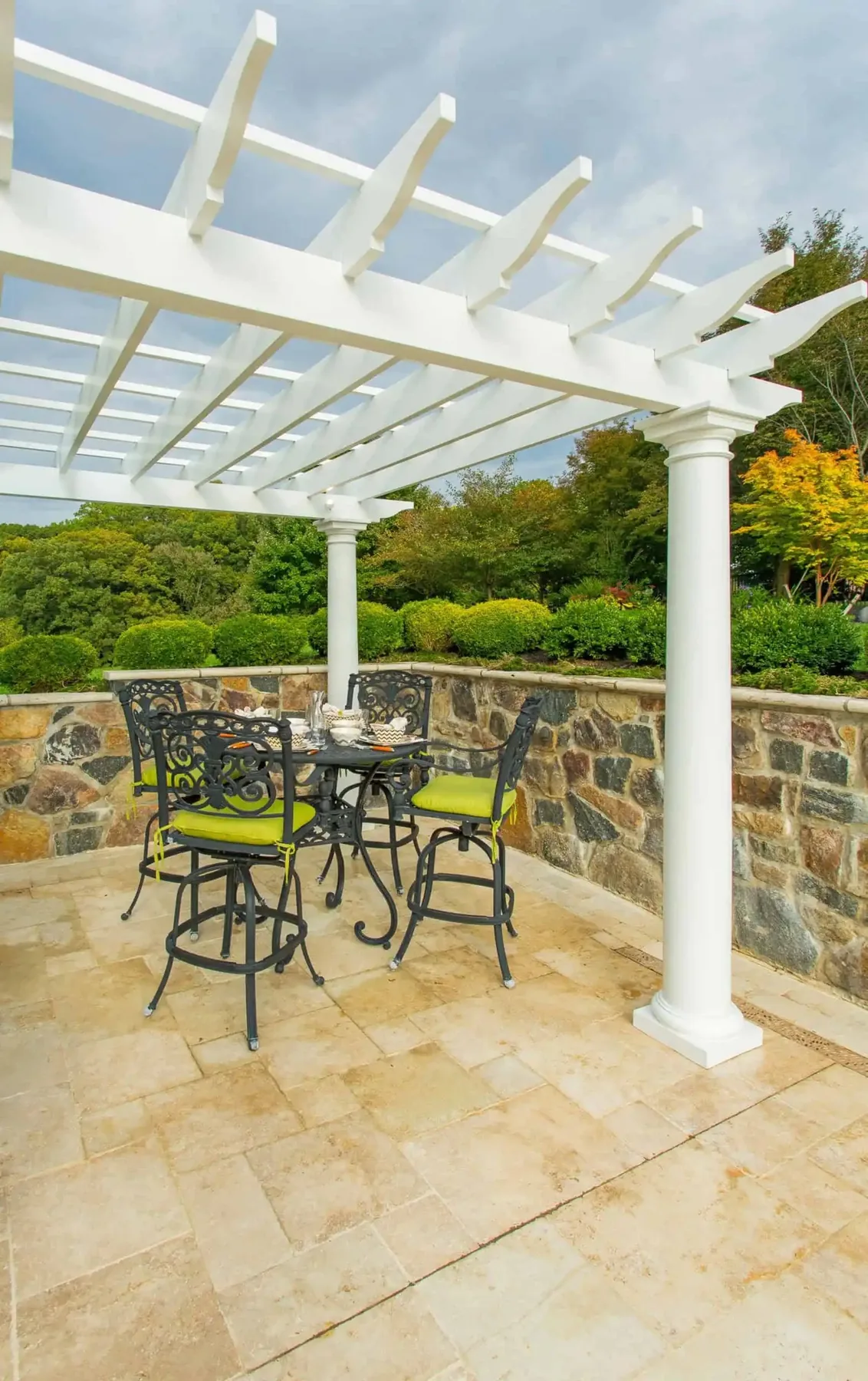 Dining table under a white pergola.