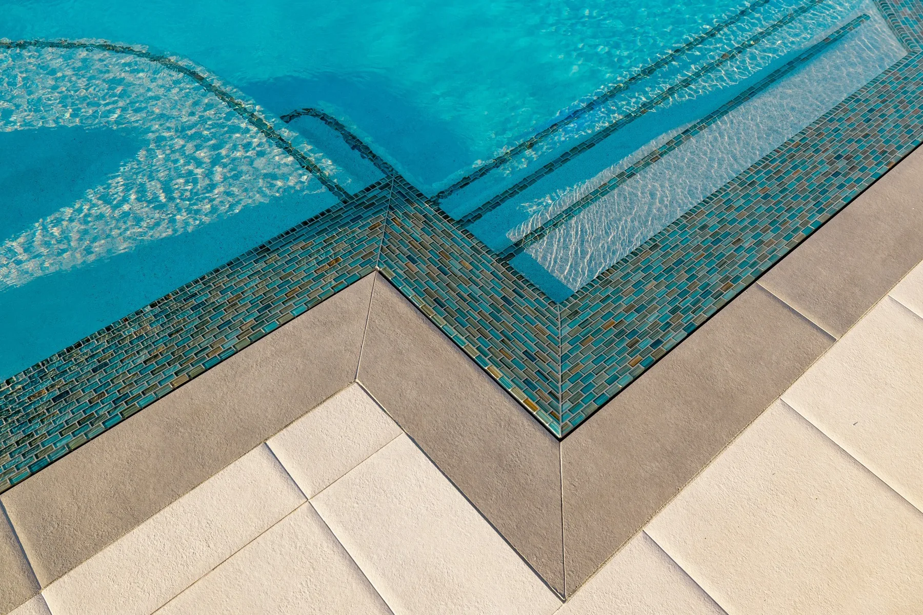 Close view of pool tile and coping.