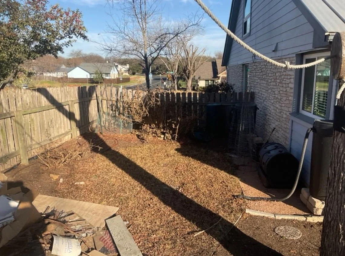 Older vertical-board fence beside the house before replacement.