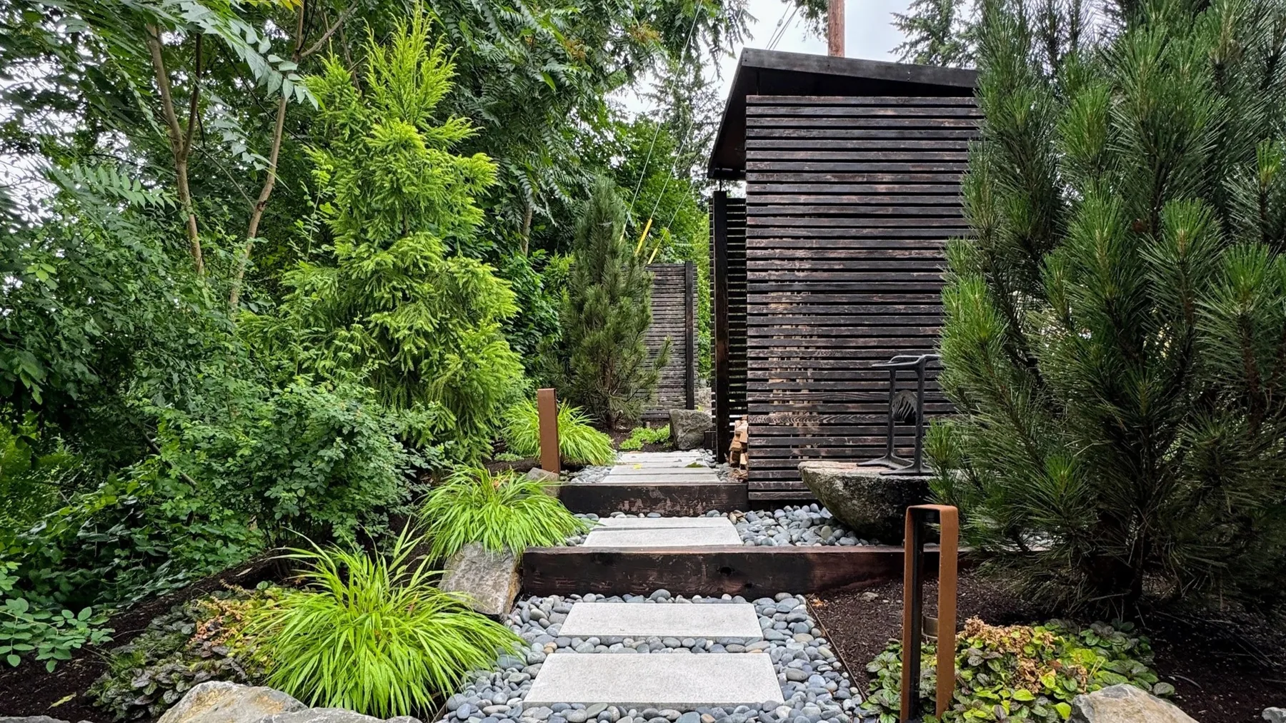 Slab path and steps between dense garden planting.