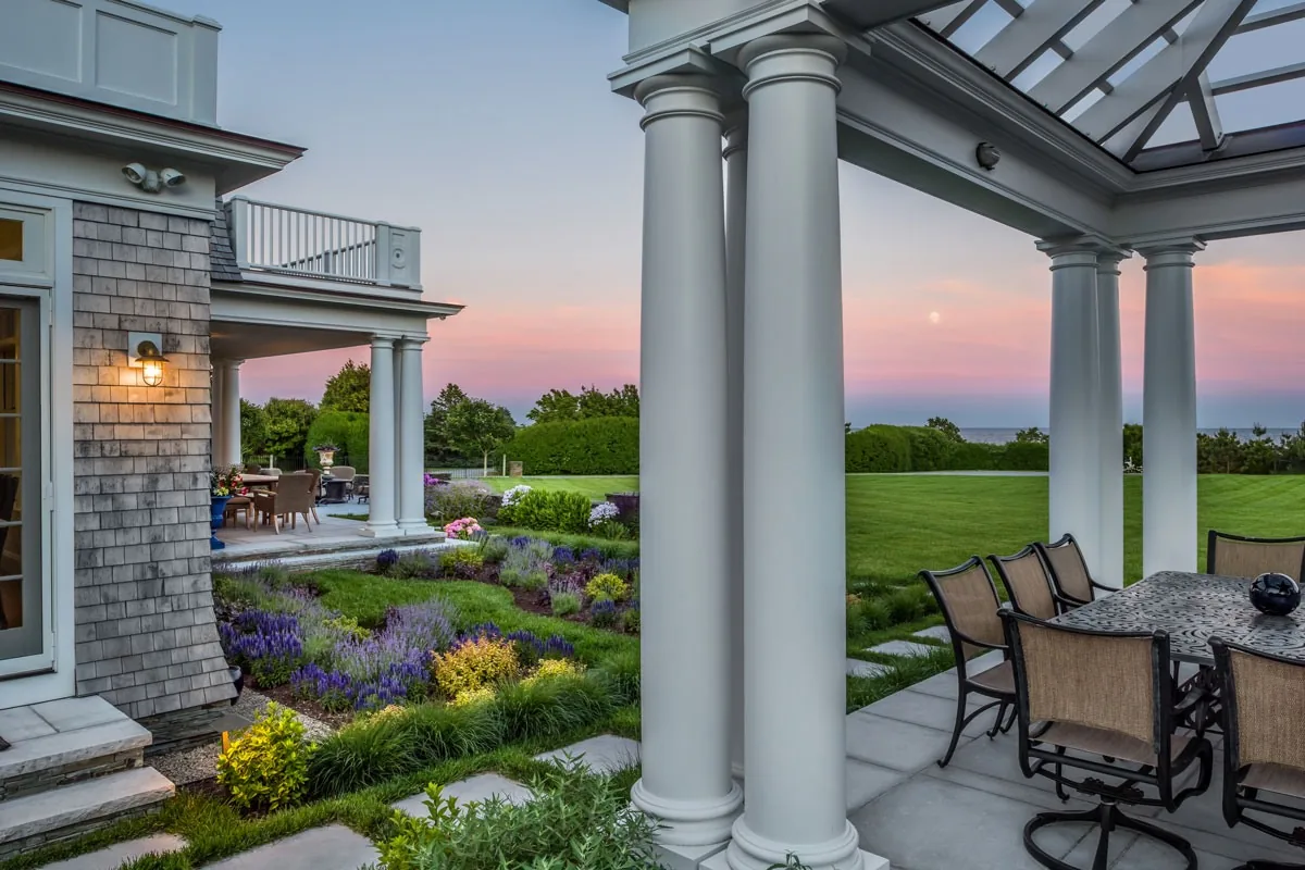 Covered dining terrace overlooking the garden and water.