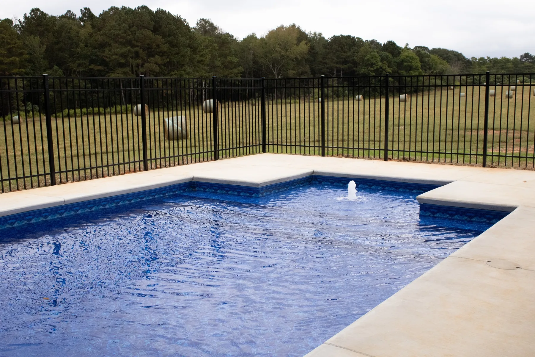 Pool water and paved edge facing an open landscape.