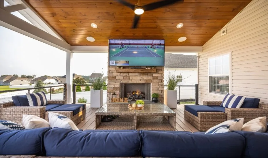 Furnished porch with fireplace beneath a timber ceiling.