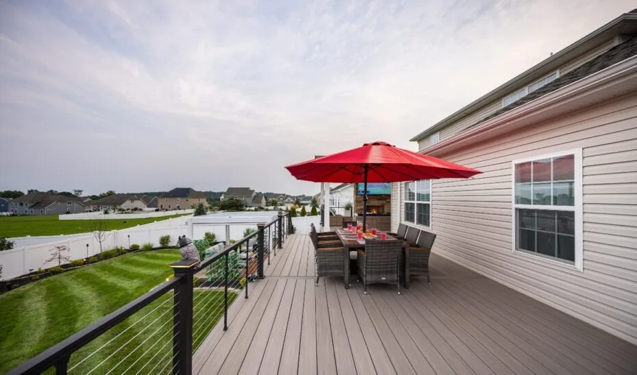 Dining table beneath a red umbrella on the open deck.