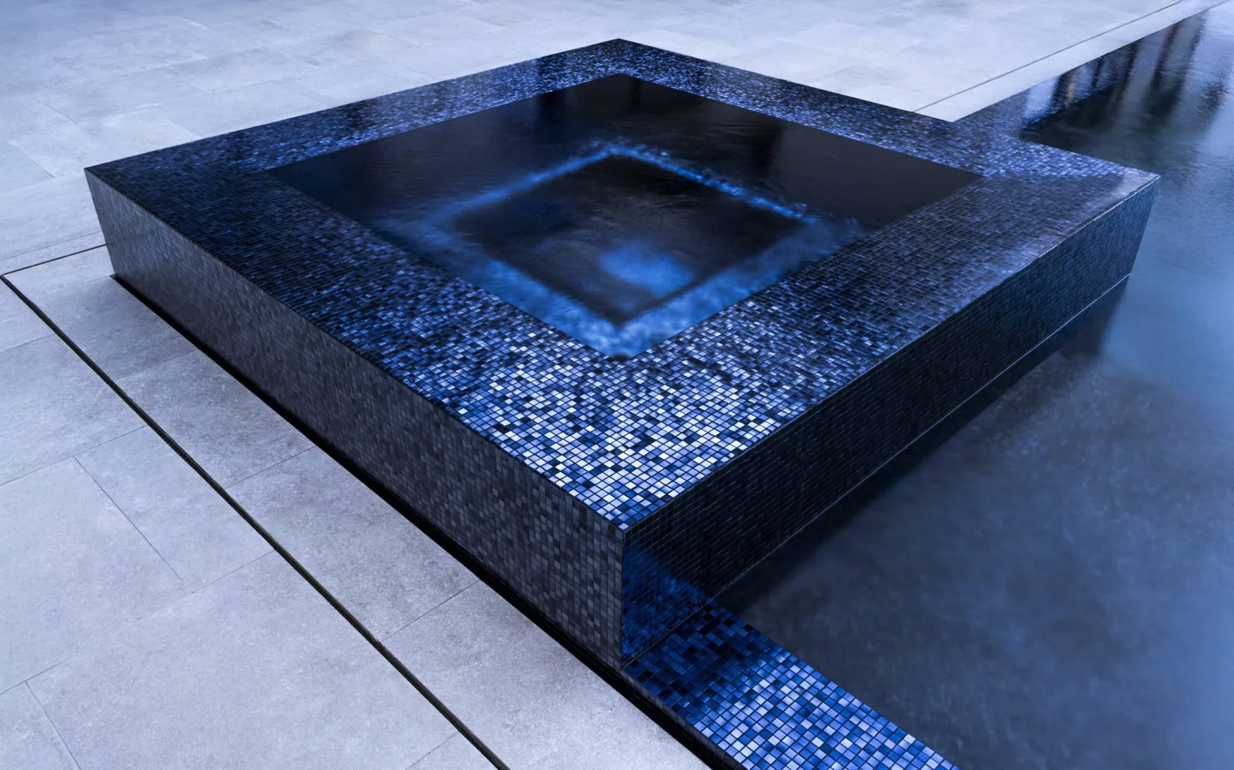 Black glass-tiled spa beside the pool.
