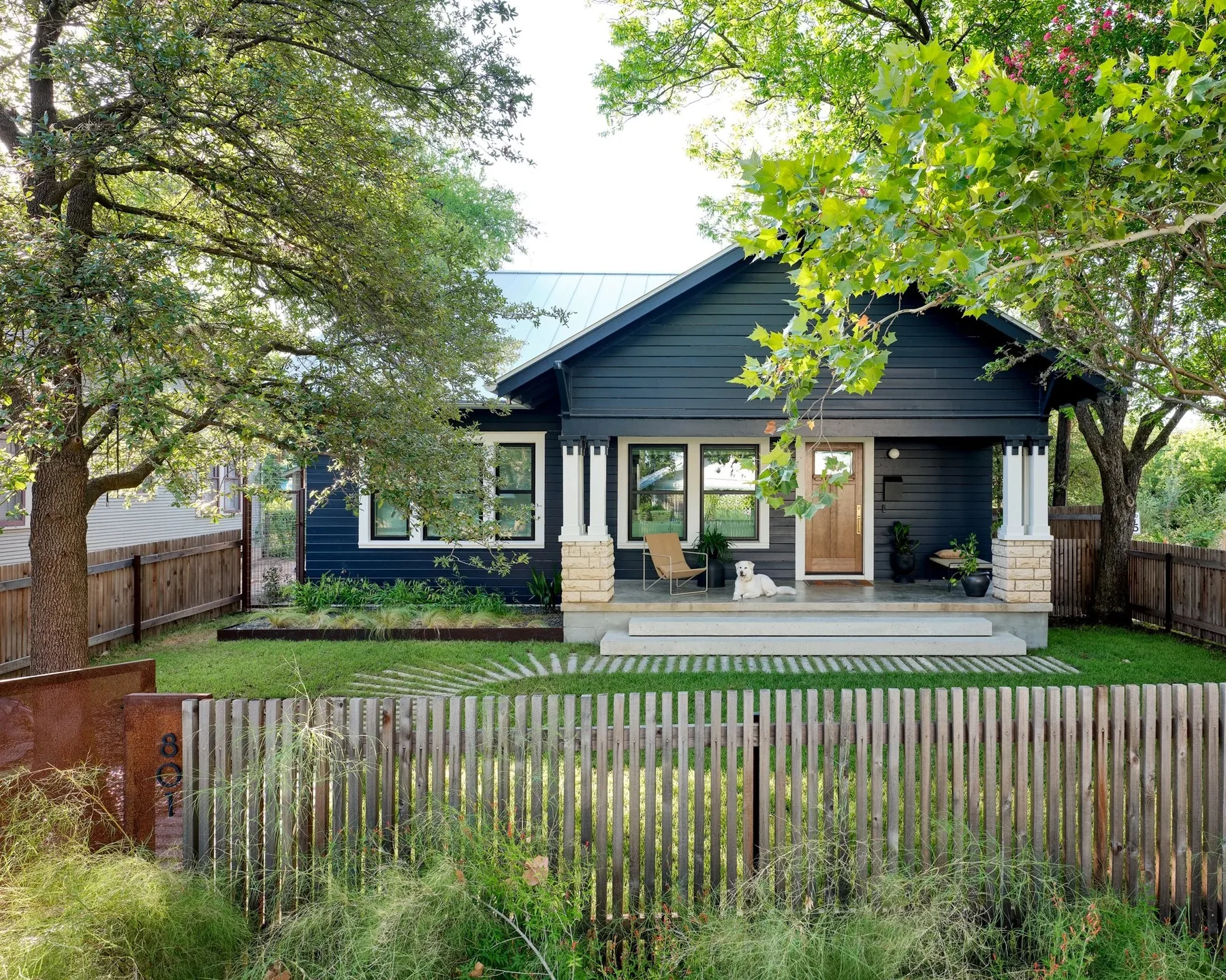Open timber fence and lawn in front of the bungalow.
