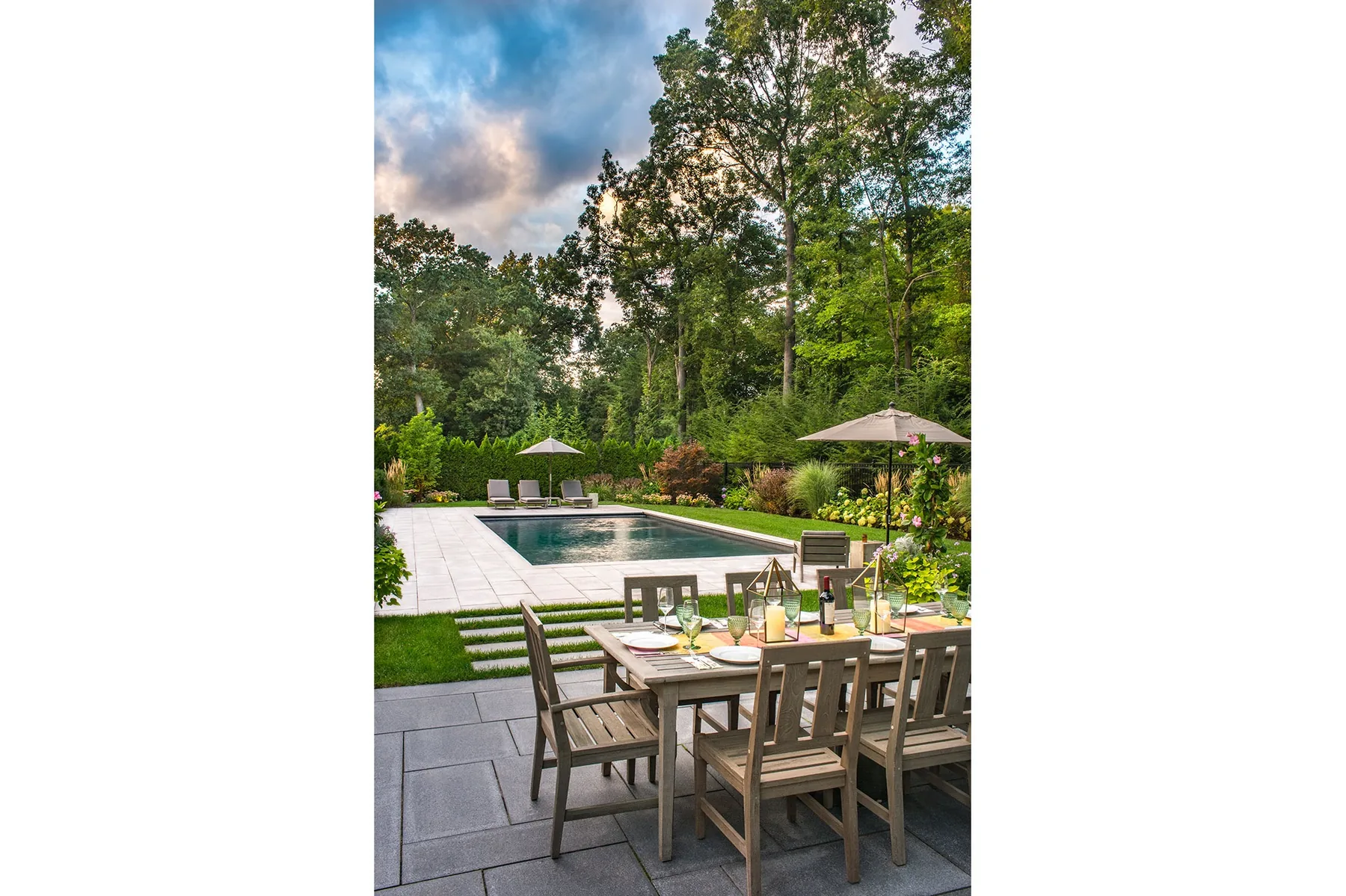 Dining table overlooking the pool and planted garden.