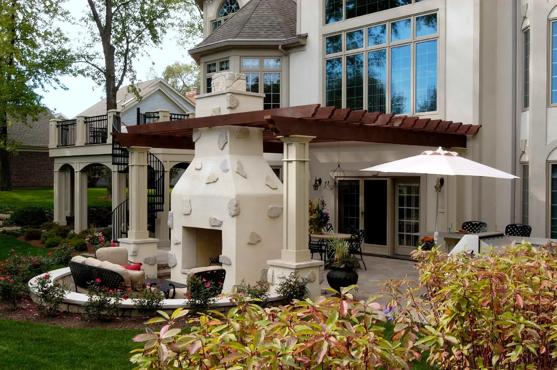 Pale fireplace and pergola beside a large home in Barrington.