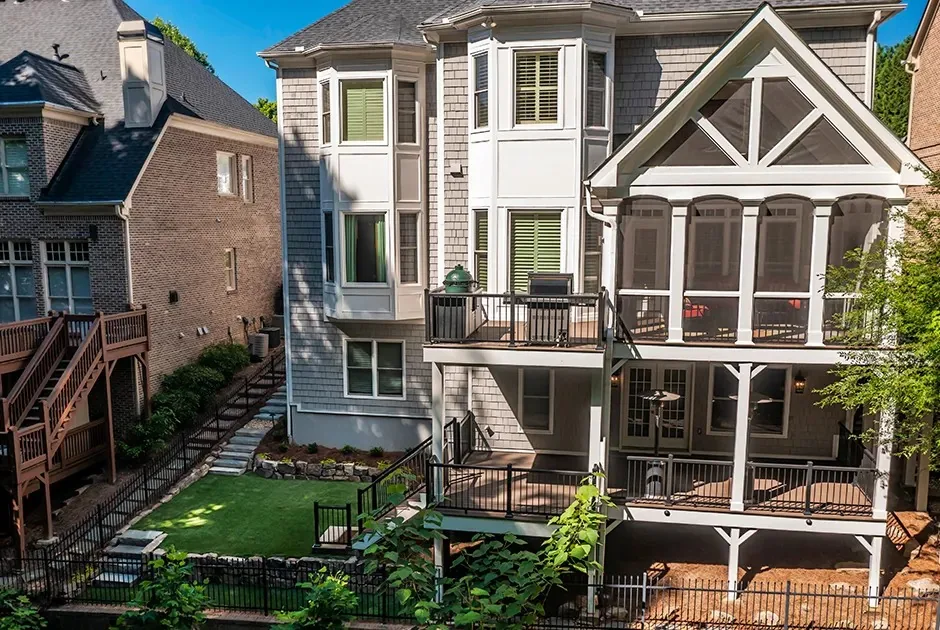 Rear of a house with screened porch, deck and stairs to the yard.