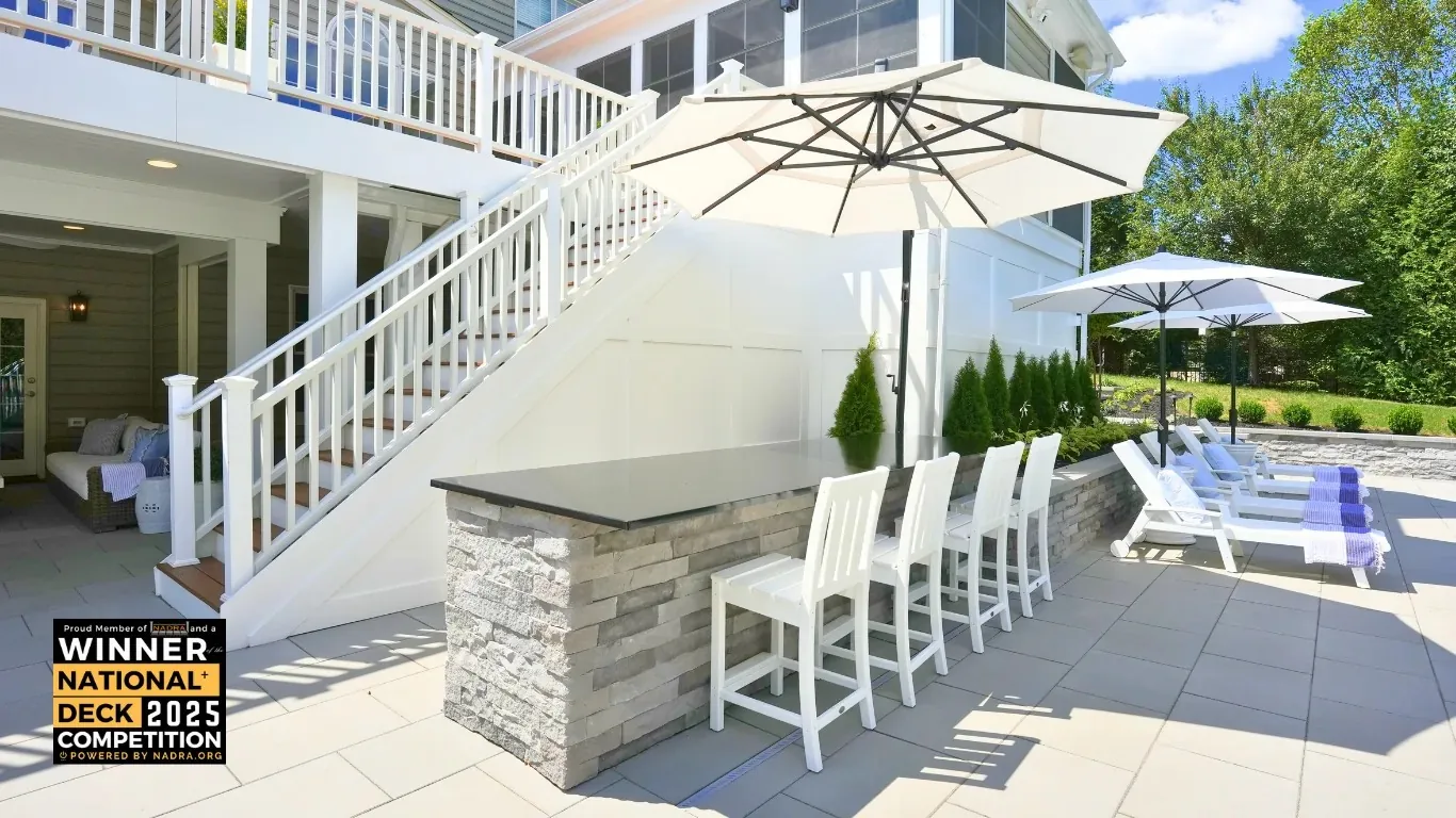 Pool terrace and bar seating below a raised deck.