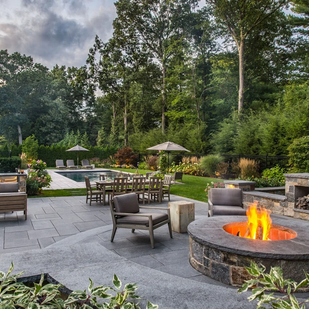 Stone terrace with fire feature, kitchen and dining area.